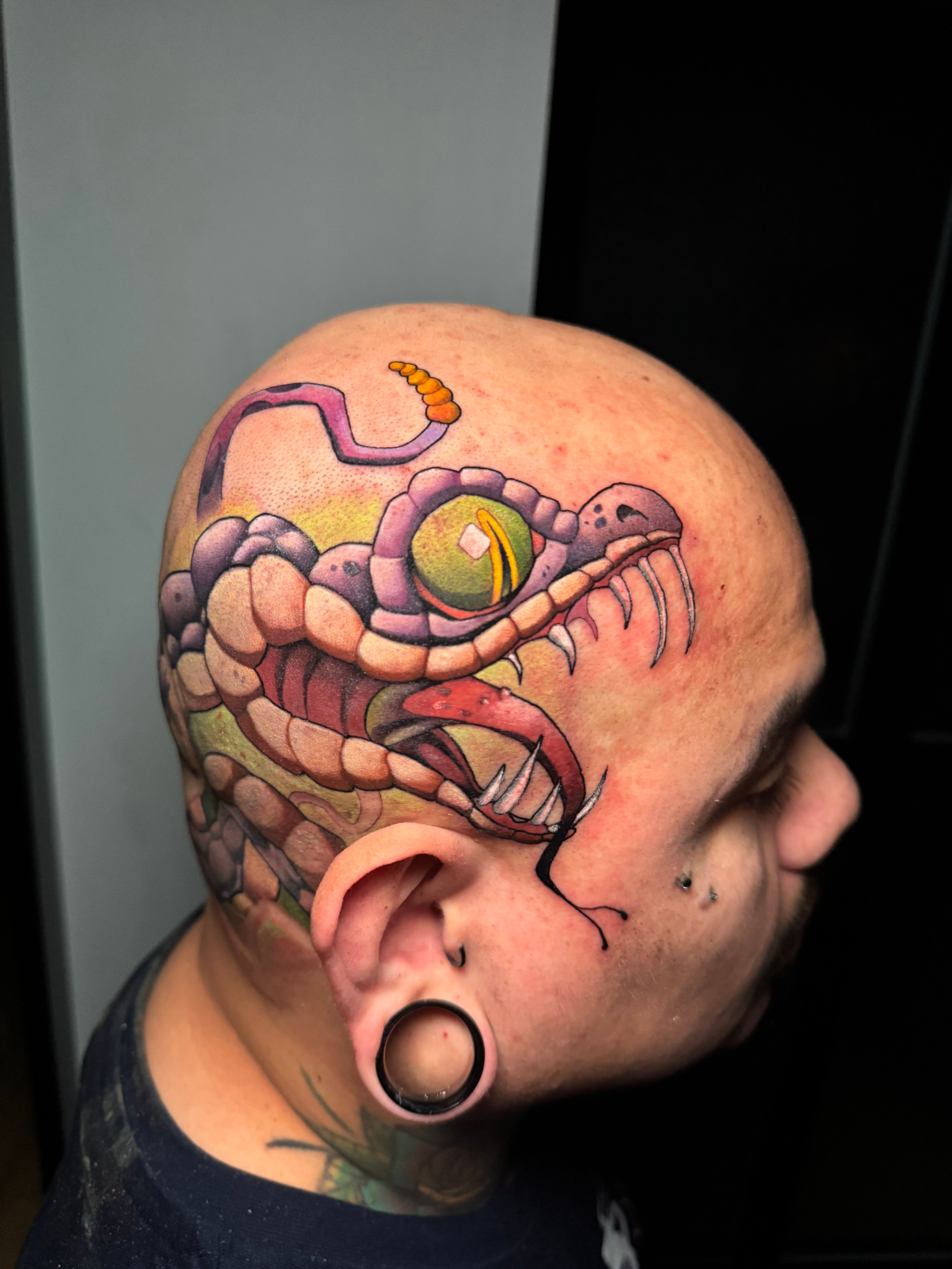 Tatuaje de cabeza de serpiente a color realizado en Madrid